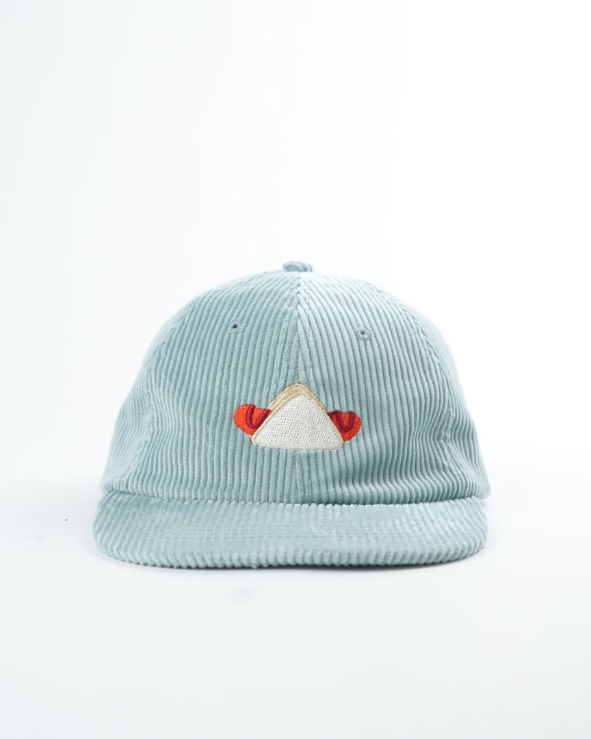 Light blue cap with embroidered design on a white background