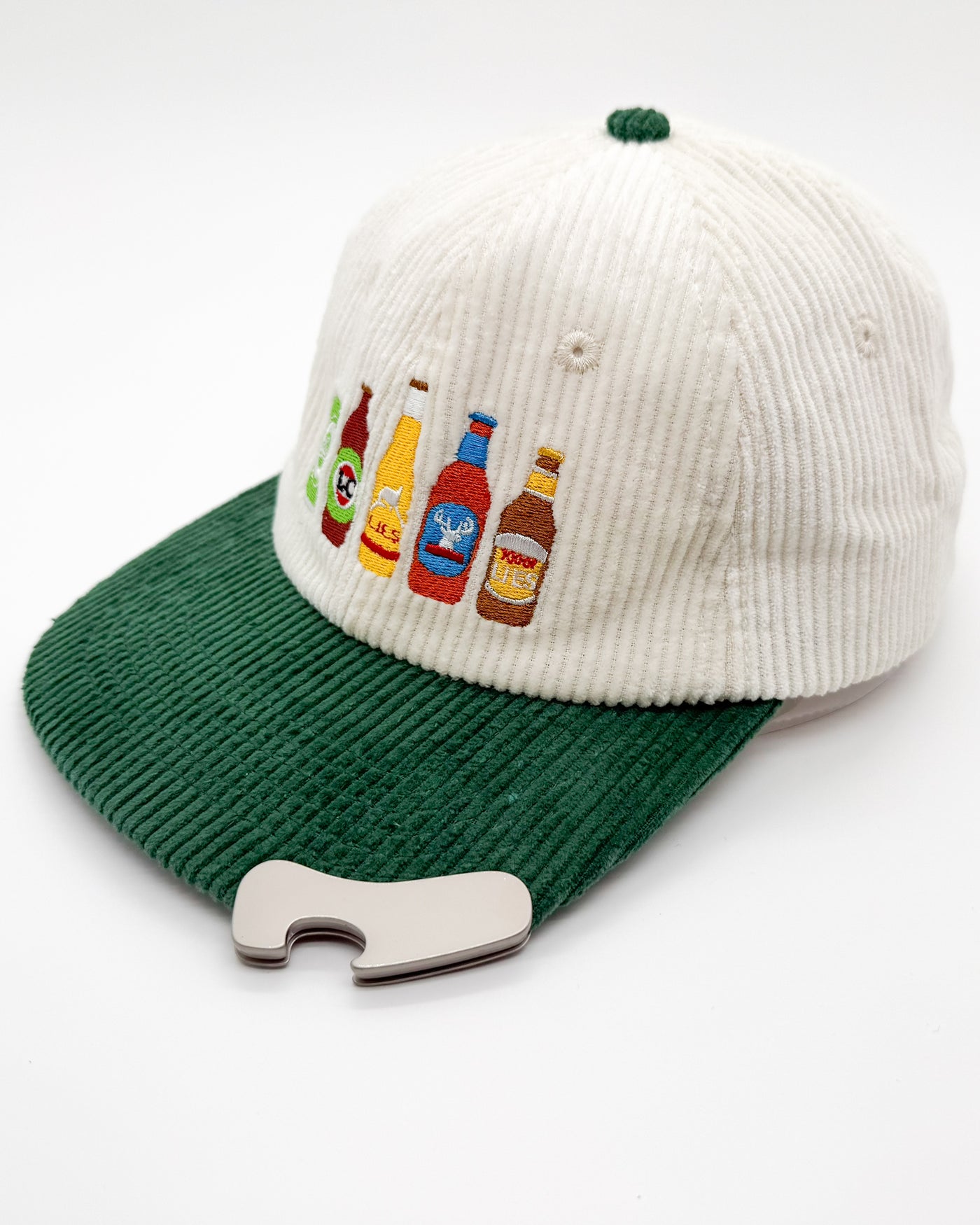 Off-white knit cap with green brim, embroidered beer bottles on front, bottle opener