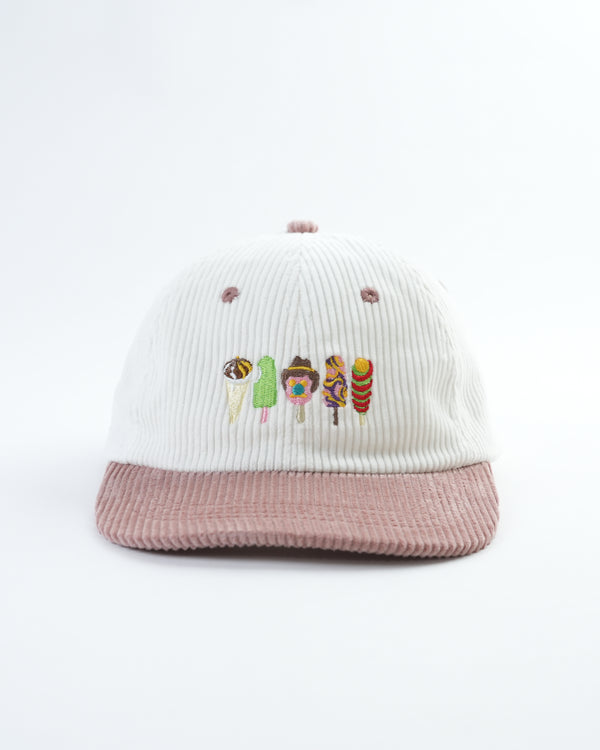 White and pink ribbed bucket hat with colorful character embroidery, studio flat lay