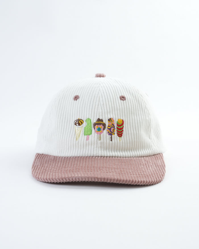 White and pink ribbed bucket hat with colorful character embroidery, studio flat lay