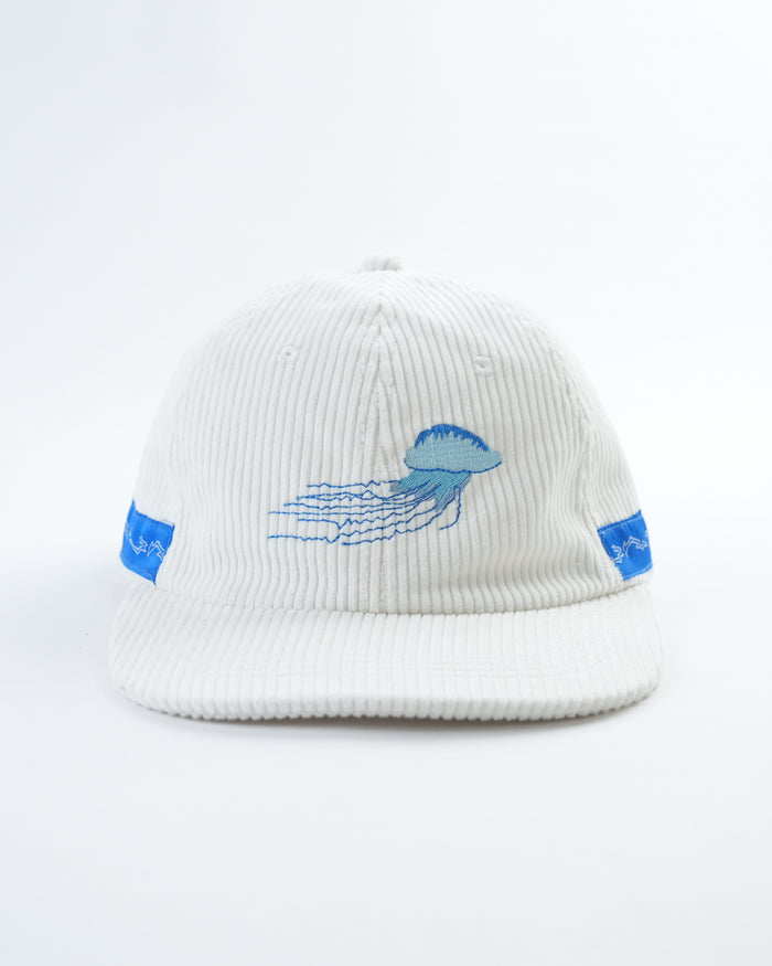 Cream ribbed baseball cap with blue jellyfish wave logo