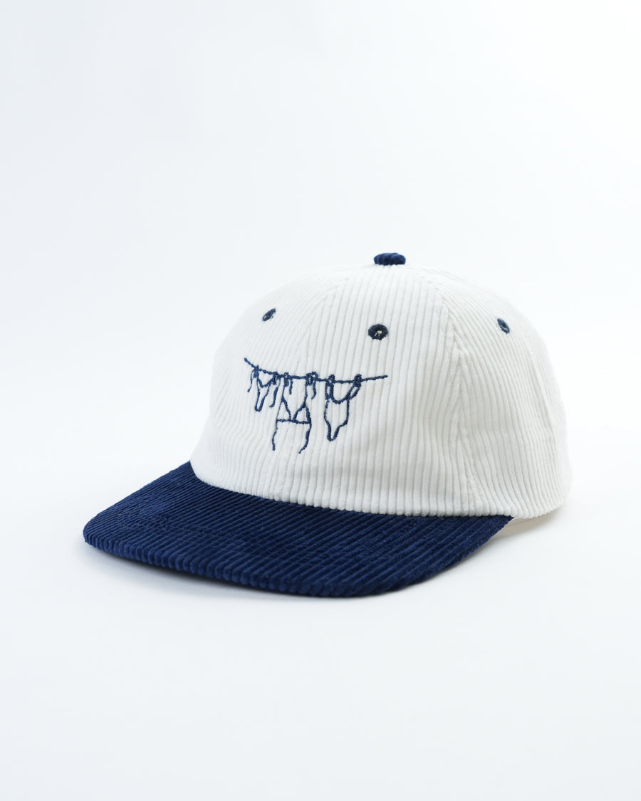 White and navy baseball cap with embroidered smiling face graphic