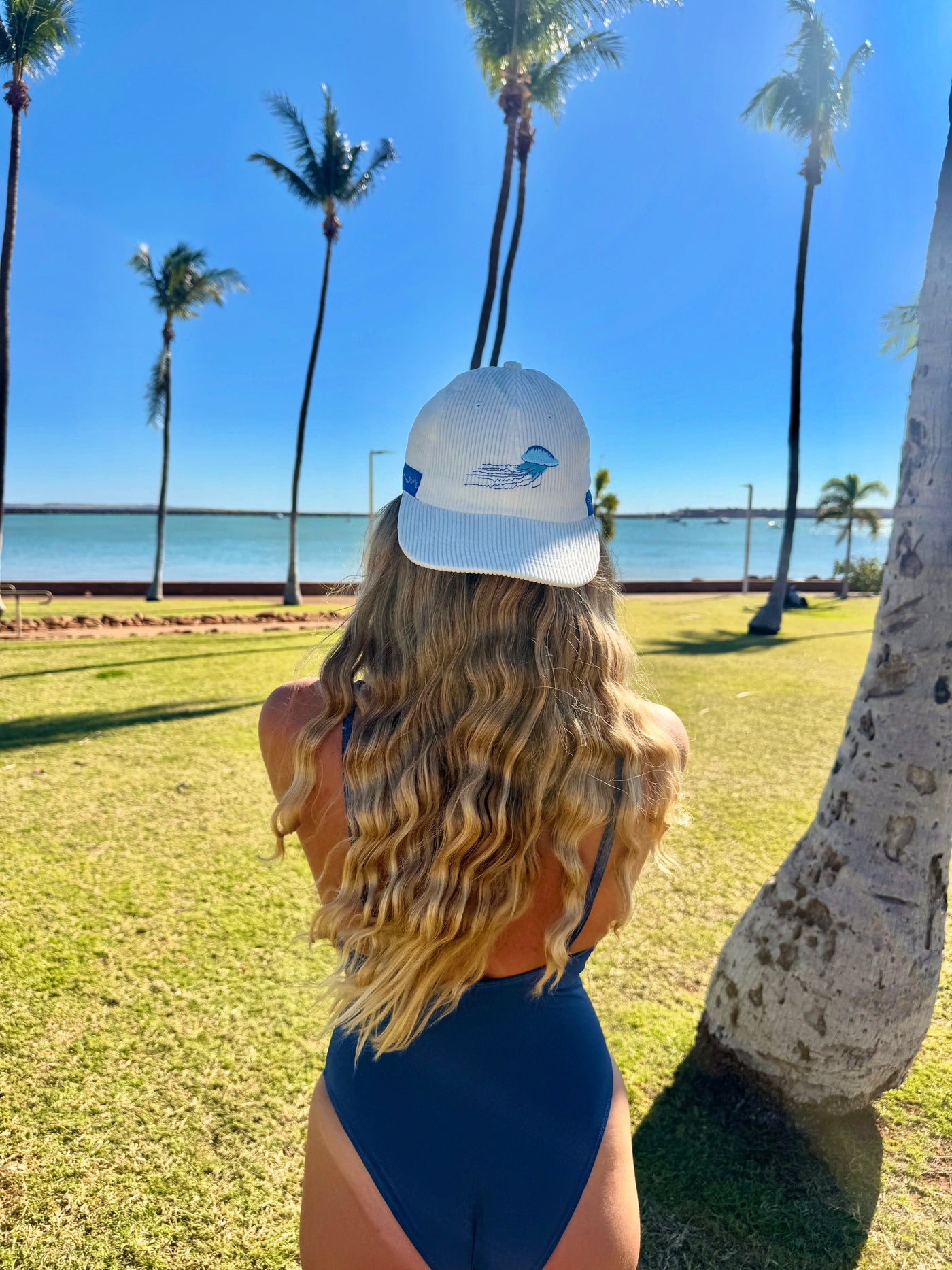 Light gray baseball cap with front logo patch and curved brim