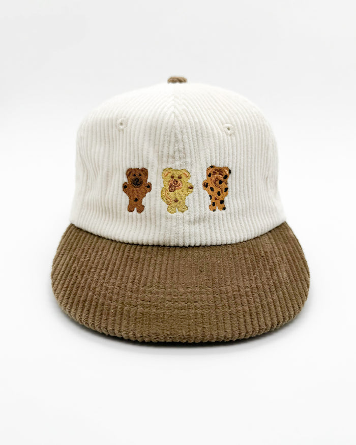 Children's bear hat with white ribbed crown, brown corduroy brim, and three bear patches