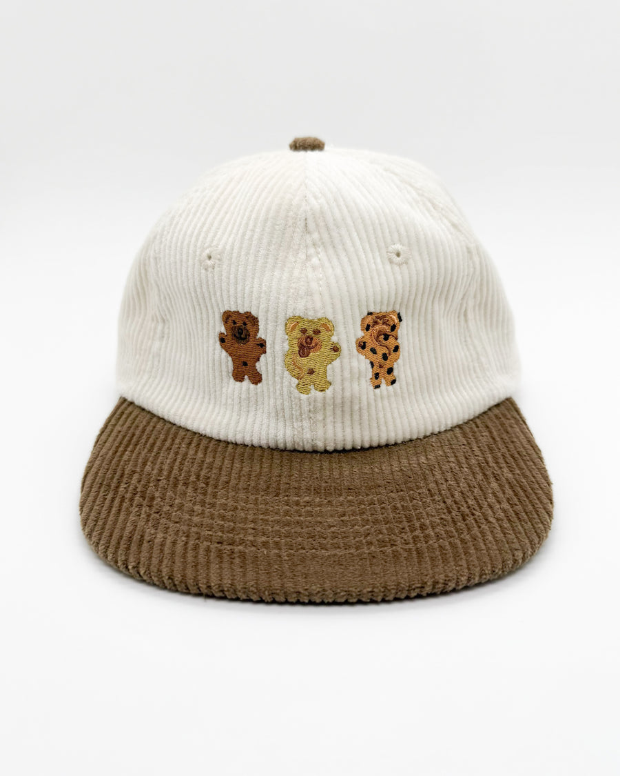 Bikkie cub mini hat with white knit crown, brown brim, and three bear face patches