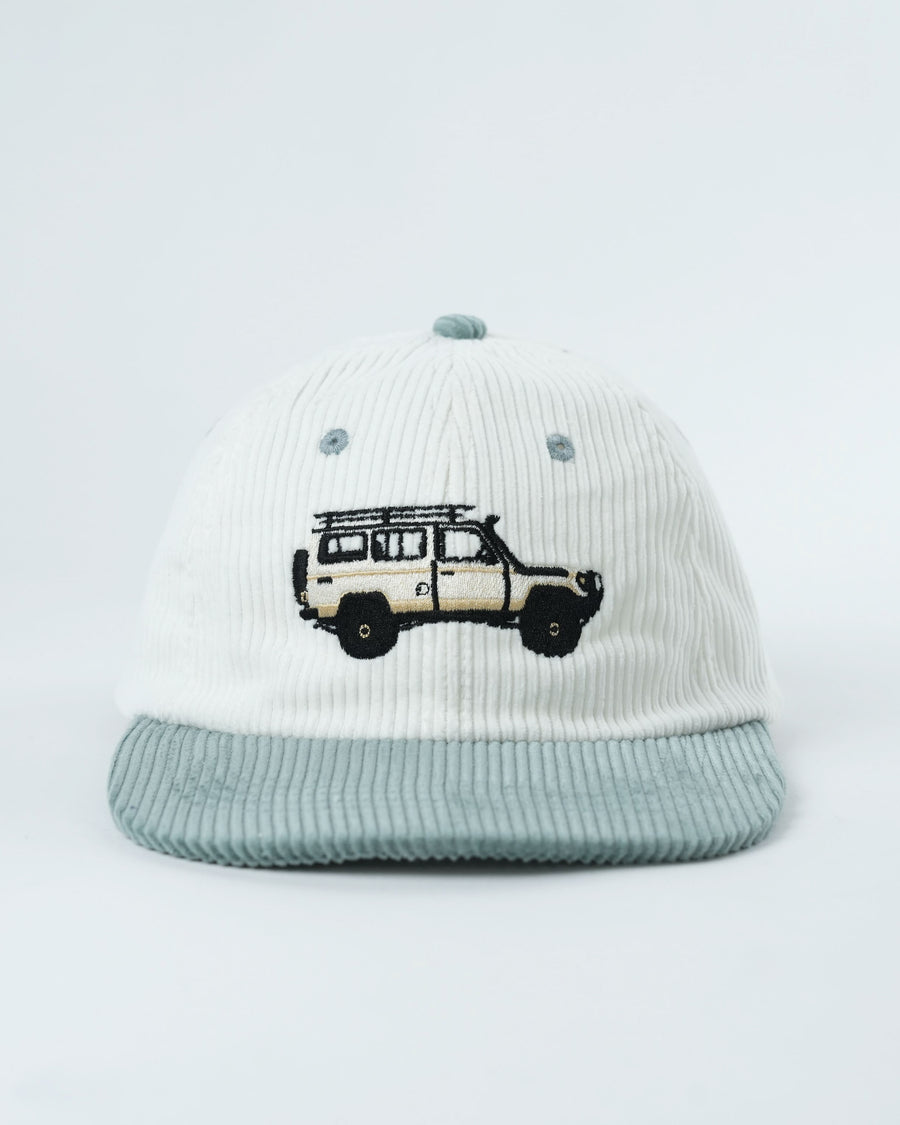 Troopy hat in white corduroy with teal-striped brim and van graphic.